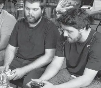  ?? TONY DAVIS/THE GUARDIAN ?? Cousins Jacob Gallant, left, and Dan Gallant play a game of Super Smash Bros. Melee for Nintendo GameCube at Geno Games.