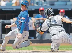  ?? AP PHOTO ?? Toronto Blue Jays’ Josh Donaldson, left, scores as New York Yankees catcher Gary Sanchez can’t make the tag during the third inning of a Major League Baseball game in New York on Tuesday.