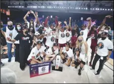  ?? Associated Press ?? In this photo provided by Bahamas Visual Services, the South Carolina women’s basketball team poses with the trophy after defeating UConn 73-57 to win the championsh­ip game on Monday at the Battle 4 Atlantis at Paradise Island, Bahamas.