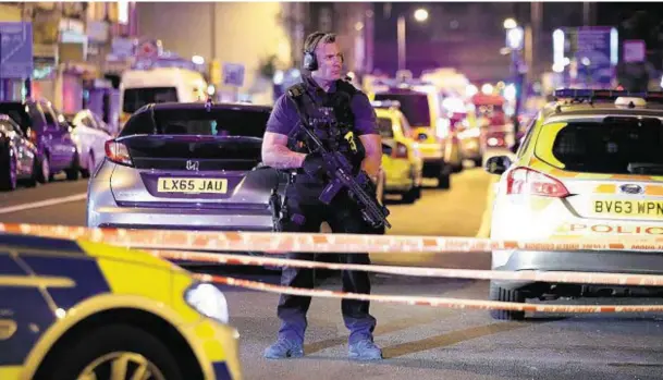  ??  ?? ON ALERT: An armed police officer mans a cordon on the Seven Sisters Road at Finsbury Park in north London