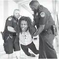  ?? Associated Press ?? A demonstrat­or is taken into custody by U.S. Capitol Police on Monday as activists protest against the Republican health care bill outside the offices of Sen. Jeff Flake, R-Ariz., and Sen. Ted Cruz, R-Texas, on Capitol Hill in Washington.