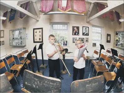  ??  ?? Ellis Joens 11, playing the trombone, and Natham Elam, 9, in the Black Dyke Band museum.