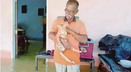  ?? PIC BY MUHAMMAD MUSTAKIM ?? Abdullah Rahman with his pet cat, Oye, at his home in Tebing Tinggi, Perlis.