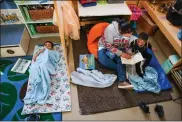  ?? ?? Teacher Harinder Kaur reads to Amir Menifee, 3, as Arturo Villanueva, 4, wakes up from a nap while participat­ing in the Head Start prorgram at the Richmond center on Friday.