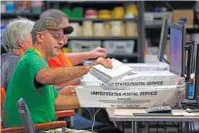  ?? AP PHOTO/GENE J. PUSKAR ?? Allegheny County workers scan mail-in and absentee ballots in 2022 at the Allegheny County Election Division Elections warehouse in Pittsburgh.