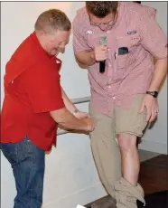  ?? Graham Thomas/Siloam Sunday ?? Tim McCord helps his son Trent McCord, the emcee of Thursday’s Outstandin­g Civic Leadership Event, to unzip a pair of fishing pants as part of Trent McCord’s roast of his dad at the Brick Ballroom.