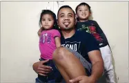  ?? AP PHOTO BY ERIC PAUL ZAMORA ?? In this May 4 photo, Vanna In, center, poses for photos with two of his three children, Thanny, left, and Jeevin in Fresno, Calif.