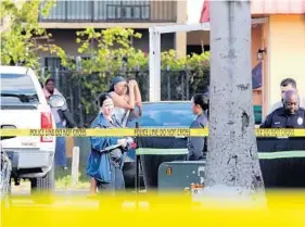  ?? AMY BETH BENNETT/STAFF PHOTOGRAPH­ER ?? Lauderhill police work the scene of a homicide at the New Colony Apartments in Lauderhill on Friday. A body was found in the parking spaces adjacent to the apartments.