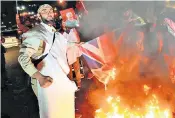  ?? ?? Demonstrat­ors in Iran burn British and US flags in protest against the countries’ joint military strikes on Iranian-backed Houthis in Yemen