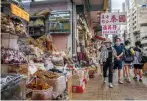  ?? Photo: AFP ?? People walk past a shop selling shark fins. The city is one of the largest importers of the fins.