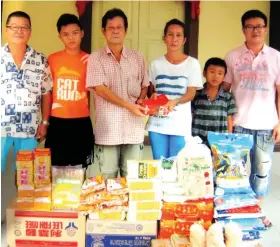  ??  ?? Lim (third left) hands over the donations and angpow to the Salvation Army Boys Home’s office representa­tive, identified only as Mai.