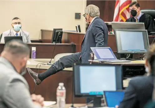  ?? PHOTOS BY JAVIER GALLEGOS/THE NEW MEXICAN ?? Defense attorney Don Cron, center, raises his leg with his pant tucked into his sock in a demonstrat­ion regarding Edwin Anaya’s clothing the night Peter Gurule was killed in January 2021. The defense wrapped up its case, and after closing arguments Tuesday in First Judicial District Court, the jury began weighing the evidence. While Anaya was able to present a clear version of events that explained the shooting, Cron said, the state did no such thing.