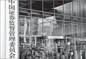  ?? PROVIDED TO CHINA DAILY ?? A pedestrian stands next to the China Securities Regulatory Commission office building in Beijing.