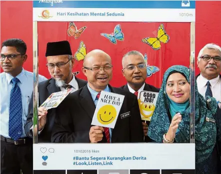  ??  ?? Helpful book: Dr Sha’ari (third from left) with fellow officers at the launch of World Mental Health Day 2016. — Bernama Dr T. Maniam