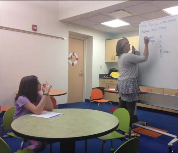  ?? JORDANA JOY — THE MORNING JOURNAL ?? Ava Leslie, 10, of Vermilion and Battle of the Books supervisor Bethany Schmitkons talk books at a weekly meeting at Ritter Public Library, 5680 Liberty Avenue in Vermilion.