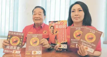  ?? ?? Wong and Lau hold up the PSB manifesto in multiple languages during the news conference.