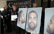  ?? MARCIO JOSE SANCHEZ — THE ASSOCIATED PRESS ?? Garden Grove Police Chief Tom DaRe, center, and PIO Carl Whitney address the media next to a booking mug shot of Zachary Castaneda posted outside of the Garden Grove Police Department headquarte­rs in Garden Grove Thursday. Investigat­ors believe Castaneda, a documented gang member, stabbed several people to death and wounded a few others as he targeted his victims at random during a bloody rampage across two Southern California cities, authoritie­s said.