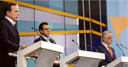  ?? Suamy Beydoun/Agif ?? O ex-prefeito João Doria (PSDB) fala ao lado do candidato petista, Luiz Marinho, e do governador, Márcio França (PSB), durante o debate que foi promovido na TV Gazeta, em São Paulo, na noite deste domingo (16)