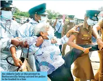  ??  ?? An elderly lady at the protest in Battaramul­la being carried by police to be loaded to a bus