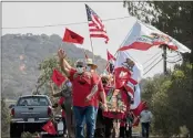  ?? RAHUL LAL/FOR CALMATTERS ?? Protesters wave to passersby, on Sept. 25, 2021in Yountville as they make their way towards PlumpJack Winery, owned by Gov. Gavin Newsom, to protest the governor’s veto of bill AB 616.