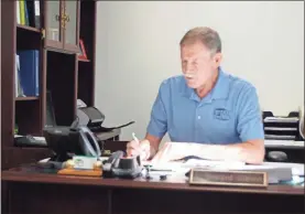  ?? Doug Walker ?? Rome-Floyd County Building Inspection Director Howard Gibson makes notes while speaking to a developer via speaker phone.