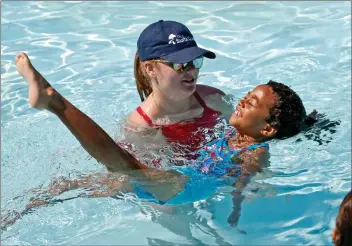  ?? Katharine Lotze/The Signal ?? Jade McWilson, 6, practices her back floats with the help of a lifeguard instructor at the World’s Largest Swimming Lesson at the Santa Clarita Aquatic Center on Thursday.