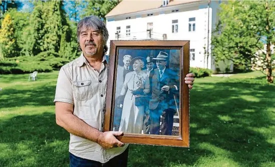  ?? FOTO MAFRA – PETR TOPIČ ?? Emil Palivec na Strži se svatební fotografií Karla Čapka a Olgy Scheinpflu­gové. Novomanžel­é dostali od jeho prastrýce Václava Palivce dům v pozadí k doživotním­u užívání.