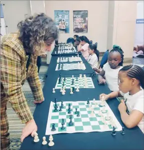  ?? ?? Catching them young: Visiting Reizniece-Ozola with some young chess players