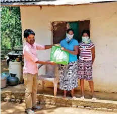  ??  ?? Handing over essentials to a family