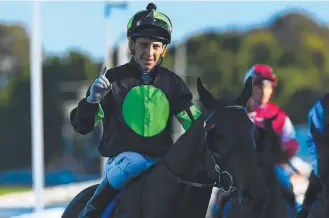  ??  ?? Jockey Jag Guthmann-Chester gestures after riding Lothario to victory on the Gold Coast.