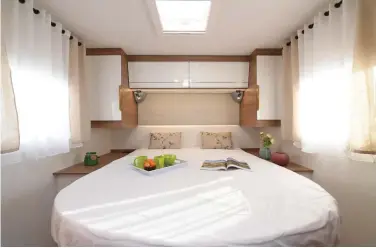  ??  ?? La chambre cosy dispose d’un lit central de bonnes dimensions (150 x 190 cm) et offre confort et luminosité.
Avec 100 cm de hauteur utile, la soute est un peu juste pour loger un deux-roues en position verticale.