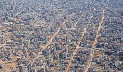  ?? LEO CORREA/AP ?? Destroyed buildings are seen through the window of a U.S. Air Force plane flying over the Gaza Strip on Thursday. The Israeli military said Wednesday it will go ahead with its planned offensive in the southern Gaza city of Rafah.