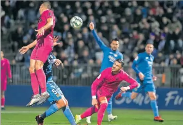  ??  ?? Juankar, del Málaga, despeja el balón ante la oposición de Juanma, capitán del Fuenlabrad­a.