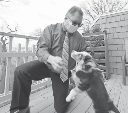  ??  ?? Dr. Mark Kittleson plays with his dog, Toby. Kittleson said it’s important to remain active. “We’re not meant to be cooped up inside,” he said. PETER CARR/USA TODAY NETWORK