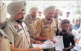  ?? HT PHOTO ?? A villager handing over an affidavit, pledging to stay away from drugs, to SSP (rural) Surjit Singh at Khurshidpu­ra village in Ludhiana on Saturday.