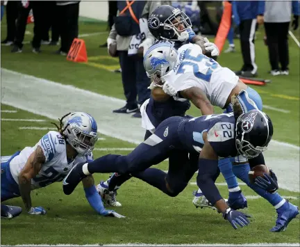  ?? PHOTOS BY BEN MARGOT — THE ASSOCIATED PRESS ?? Tennessee Titans running back Derrick Henry, right, scores against the Detroit Lions during Detroit’s 46-25 road loss on Sunday.