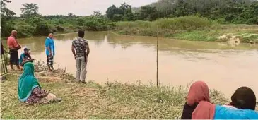  ??  ?? KELUARGA mangsa menunggu di lokasi kejadian.