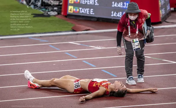  ?? ?? A Japanese official checks on Spain's Lucia Rodriguez after Heat 1 of the first round of the women's 5000-meter qualificat­ion race at Tokyo's Olympic Stadium on July 30.
Mark Edward Harris © All rights reserved.