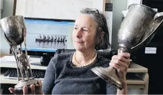  ?? A L L E N MC I N N I S / MO N T R E A L G A Z E T T E ?? Sonni Malo, vice- president of St- Lambert’s Mouillepie­d Historical Society, displays two old trophies in Montreal on Wednesday. The trophies were found in the garbage and subsequent­ly donated to the society.