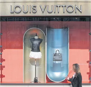  ?? REUTERS ?? A woman walks past a Louis Vuitton shop in Brussels.