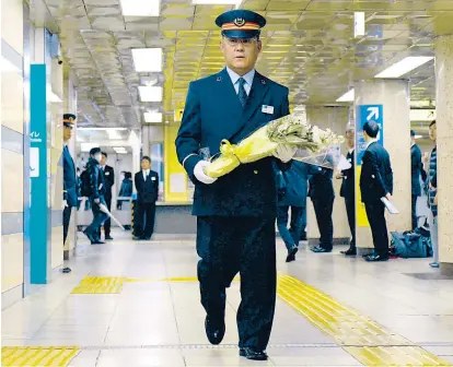  ??  ?? Jährlich gedenkt der Leiter der U-Bahn-Station Kasumigase­ki gemeinsam mit seinen Mitarbeite­rn den Opfern des Saringasan­schlags vom 20. März 1995. Es starben 13 Menschen, tausende wurden verletzt.