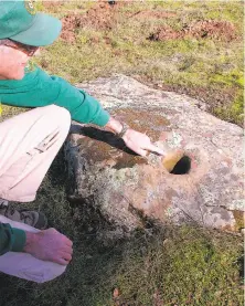  ?? Tom Stienstra / The Chronicle ?? Ned MacKay of the East Bay Regional Park District points out an ancient mortar at Morgan Territory Regional Preserve.