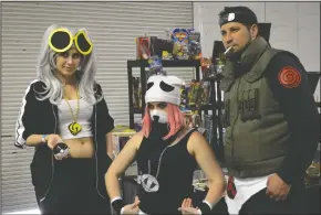  ??  ?? Taylor Rolicheck of Modesto, left, and Pauline Espinoza of Sacramento — dressed as Team Skull Leader Guzma and a Team Skull Grunt from the video game “Pokemon Sun and Moon” — pose for a picture with Justin Gomes of Manteca, right, who was dressed as...
