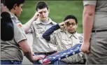  ?? COX MEDIA GROUP ?? Boy Scout Troop 47 in Brookville, Ohio, helps retire a flag Wednesday.
The program will be renamed Scouts BSA in 2019 to reflect its new gender inclusivit­y.