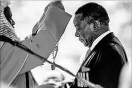  ?? JEKESAI NJIKIZANA/GETTY-AFP ?? New Zimbabwean President Emmerson Mnangagwa receives the chain and sash of office.