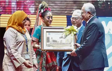  ??  ?? Strong foundation­s: Najib receiving a memento after opening the Ninth World Urban Forum in Kuala Lumpur. Looking on are Maimunah (left) and Noh Omar.