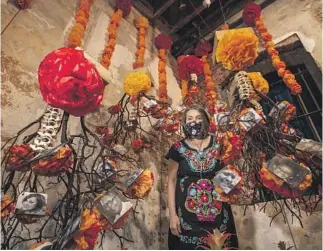  ?? Mel Melcon Los Angeles Times ?? CONSUELO G. FLORES stands in the altar she designed in tribute to Black and brown victims of COVID-19 at Self Help Graphics & Art in Los Angeles, one of several Día de los Muertos events.