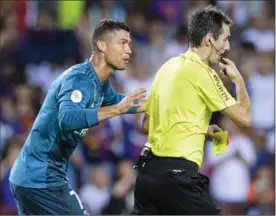  ?? GETTY IMAGES FILE PHOTO ?? Cristiano Ronaldo of Real Madrid gets a red card during Sunday’s game against Barcelona from FIFA referee Ricardo de Burgos Bergoetxea, right.