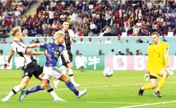  ?? ?? Takuma Asano scores Japan’s second goal in the Group E win over Germany at Khalifa Internatio­nal Stadium, Doha… yesterday.