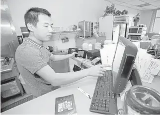  ?? JOHN MCCALL/SOUTH FLORIDA SUN SENTINEL ?? Sieng House Restaurant owner Hugo Jiang works on an order for his virtual restaurant Boca Wings at his restaurant in Boca Raton. Last year, UberEats convinced Hugo to spin off his Boca Raton Chinese restaurant into a second restaurant, a chicken-wing shack available exclusivel­y on food-delivery apps.